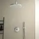 Duschelement mit runder Regendusche und Handbrause an der Wand, verchromte Armaturen von Ideal Standard, montiert über einer beige Wand.